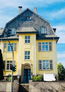 una casa amarilla con un semáforo delante de ella en Zentrale DG-Oase in Jugendstilvilla (mit Stadtblick), en Wittlich