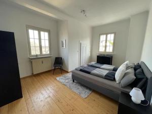 a bedroom with a large bed and two windows at Zentrale DG-Oase in Jugendstilvilla (mit Stadtblick) in Wittlich