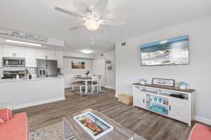a living room with a ceiling fan and a kitchen at Kiawah Bay 106 in New Smyrna Beach