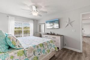 a bedroom with a bed and a ceiling fan at Kiawah Bay 106 in New Smyrna Beach +28 photos