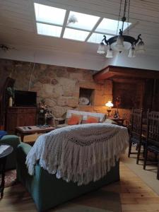 a bedroom with a bed and a stone wall at Casario do Vale Hospedagem e Eventos in Assento