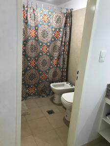 a bathroom with a toilet and a shower curtain at La Casita de DaniMar in Yerba Buena