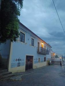un edificio blanco con un balcón en el lateral. en Casario do Vale Hospedagem e Eventos, 