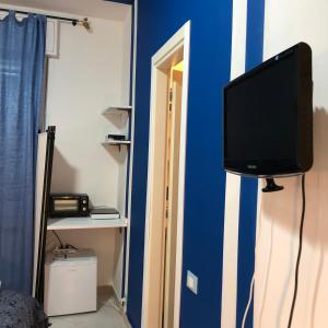 ミラノにあるB&B Apartment San Siro Stadio 132の青い壁に掛けられた薄型テレビ +44枚の写真