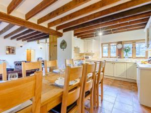 a kitchen and dining room with a wooden table and chairs at 4 Bed in Bettws Cedewain 86784 in Bettws Cedewain