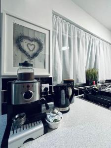 a kitchen counter with a coffee maker and a picture of a heart at Cosy Lodge for up to 9 guests near hart of Lincoln! Short let & longer bookings welcome, weekly and monthly offers in Lincolnshire
