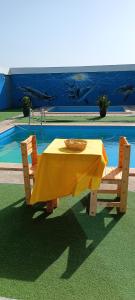 einen Tisch mit einem gelben Tischtuch neben einem Pool in der Unterkunft Espaço-Vila Verde 