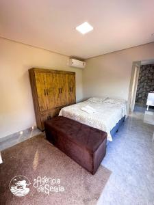 1 dormitorio con 1 cama y puerta de madera en Incrível suíte com vista para a Praia do Viana, en Ilhabela