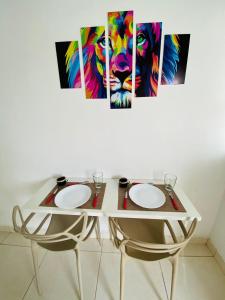 a table with two chairs and a painting of a lion at DuPai Sorocaba 11 in Sorocaba