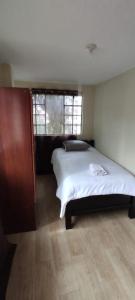 Un dormitorio con una cama grande y una ventana en 3 Cuarto independiente individual Ambato en Ambato
