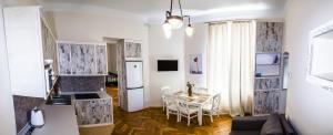 a kitchen and dining room with a table and a refrigerator at Apartments WHITE HOUSE in Lviv