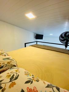 a room with a bed with a yellow blanket at DuPai Sorocaba 11 in Sorocaba