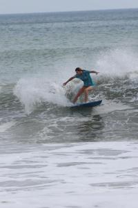 Kobieta na fali na desce surfingowej w oceanie w obiekcie Hide and Seek Resort w mieście Popoyo