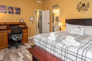 um quarto com uma secretária, uma cama e uma cadeira em The Nest-2 K Beds-Game Room-Deck-5 min to Mariposa em Mariposa
