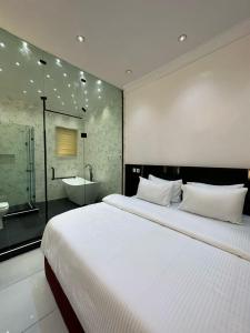 a bedroom with a large white bed and a bathroom at Light house hotel in Lekki