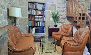 een woonkamer met 2 lederen stoelen en een glazen tafel bij Campomuiños in Pobra do Caramiñal