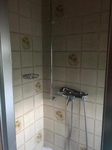 a shower in a bathroom with white tile at Haus Imgard in Lenzkirch