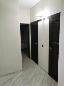 an empty room with black doors and wooden floors at Jaaniku apartment. in Ahtme