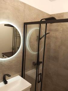 a bathroom with a shower with a sink and a mirror at Jaaniku apartment. in Ahtme