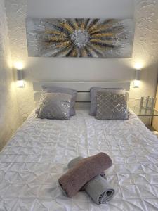 - un lit avec 2 oreillers et une serviette dans l'établissement Appartement 32m2 Juan les Pins 350 m plage climatisé WIFI centre, à Juan-les-Pins