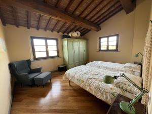 a bedroom with a bed and a chair at Villa Cerretina in Cerreto Guidi