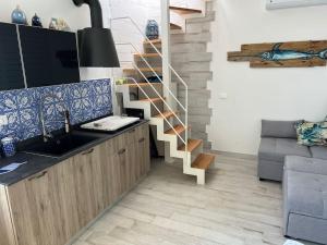 una cocina con fregadero y una escalera de caracol en Isola di Marettimo casa vacanze en Marettimo