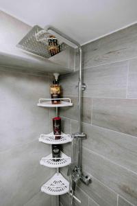 a shower with four white shelves in a bathroom at Suzana's Urban apartment in Thessaloniki