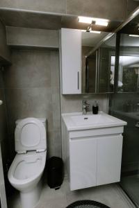 bagno con servizi igienici bianchi e lavandino di Suzana's Urban apartment a Salonicco