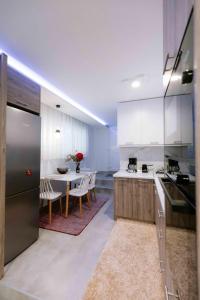 uma cozinha com armários brancos e uma mesa com cadeiras em Suzana's Urban apartment em Tessalônica