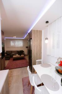 una cucina e un soggiorno con tavolo e sedie bianchi di Suzana's Urban apartment a Salonicco