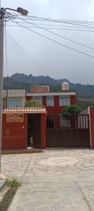 un edificio rojo con una puerta y una valla en Hospedaje Vacacional - Colca, en Chivay