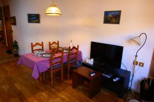 uma sala de estar com uma mesa com uma toalha de mesa rosa em Can Vilà- Vall de Camprodon em Vilallonga de Ter
