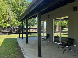a covered patio with two chairs and a table at La Abundancia Capilla del Senor in Capilla del Señor