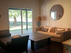 a living room with a couch and a table and a mirror at La Abundancia Capilla del Senor in Capilla del Señor