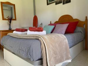 uma cama com almofadas coloridas em cima em Alquiler Mazagon Pre-Parque Doñana em Mazagón