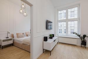 biała sypialnia z łóżkiem i oknem w obiekcie Gdansk Apartments w Gdańsku