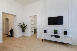 salon z telewizorem na białej ścianie w obiekcie Gdansk Apartments w Gdańsku