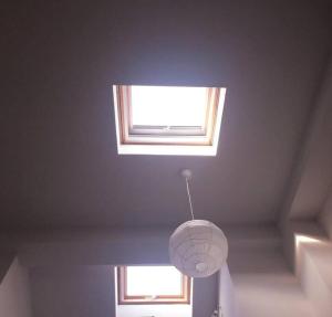 a ceiling with a light fixture and two windows at Aspa's house in Myrina