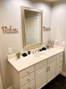 een badkamer met een wastafel en een spiegel bij Luxe Lavish w/ Pool in Houston