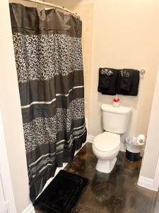 uma casa de banho com um WC e uma cortina de chuveiro em Luxe Lavish w/ Pool em Houston