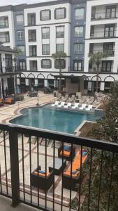 a swimming pool with lounge chairs and a building at Luxe Lavish w/ Pool in Houston