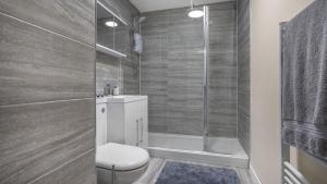 uma casa de banho com um WC e um chuveiro em Park Avenue - An Executive 2 Bed Suite Close to Birmingham City Centre em Birmingham