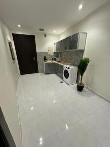 a white kitchen with a washer and dryer in it at شقه فاخره الملز in Riyadh