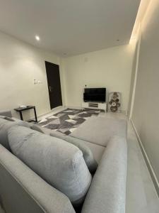 a living room with a couch and a flat screen tv at شقه فاخره الملز in Riyadh