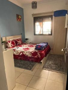 um quarto com uma cama e uma janela em Appartement 5 piscines fitness em Marrakech
