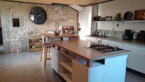 a kitchen with a counter and a stove top oven at Maison rénové en pierre in Crotenay