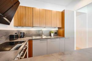 a kitchen with white cabinets and a sink at Komfortowy apartament z siłownią i sauną Revisit Apartment 11 in Łódź