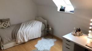 um quarto com uma cama, uma secretária e um tapete branco em Hâvre de paix em Sevran