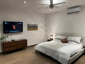 a bedroom with a bed and a flat screen tv at Residencia Corinto La Cima Frac Burgos Bugambilias in Temixco