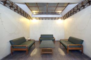 2 chaises et une table dans une salle d'attente dans l'établissement Capital O Hotel Kartik, à Jabalpur